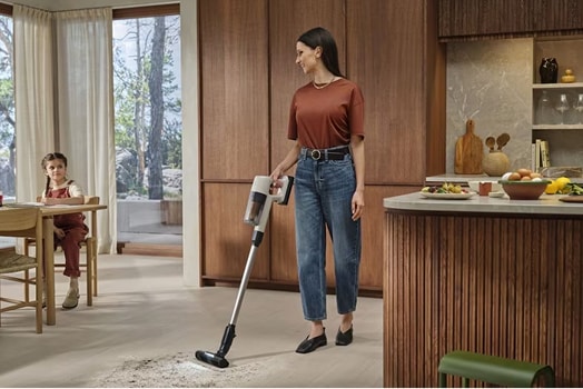 Woman cleaning floor with Cordless vacuum cleaner