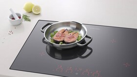Dva lahodné lososové steaky smažící se na indukční varné desce