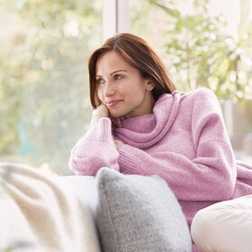 Žena těšící se ze svého vlněného svetru