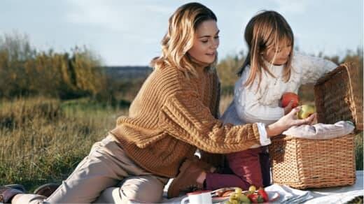 Žena a děvče mající piknik