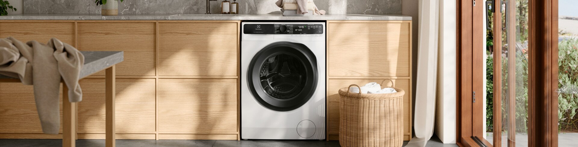 Pračka Electrolux stojí ve světlé prádelně. 