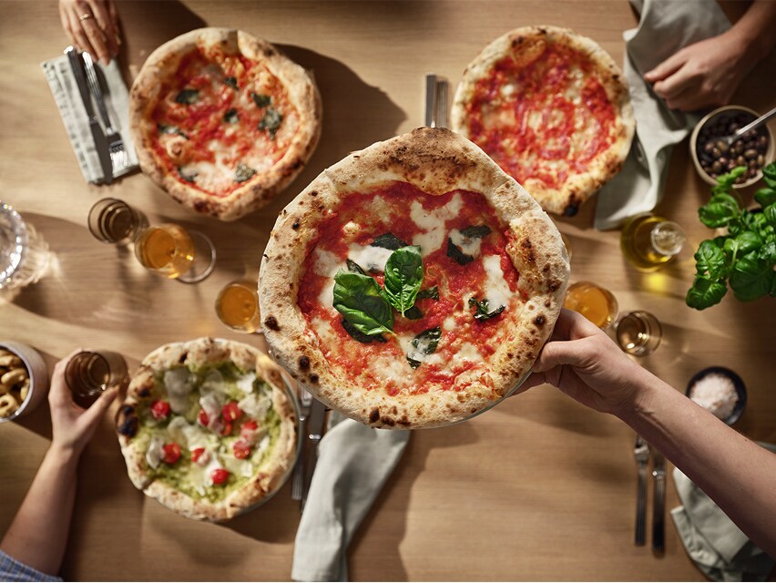 Pohled shora na čtyři pizzy.