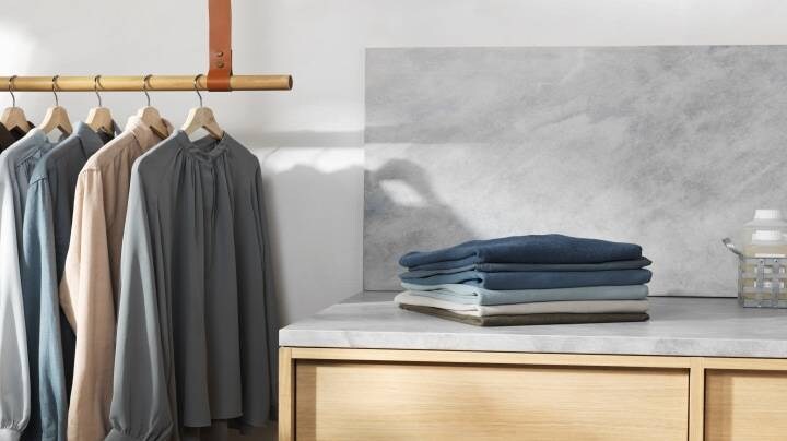 Poskládané oblečení a oblečení visící na ramínku